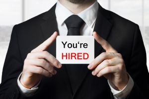 businessman holding sign you are hired